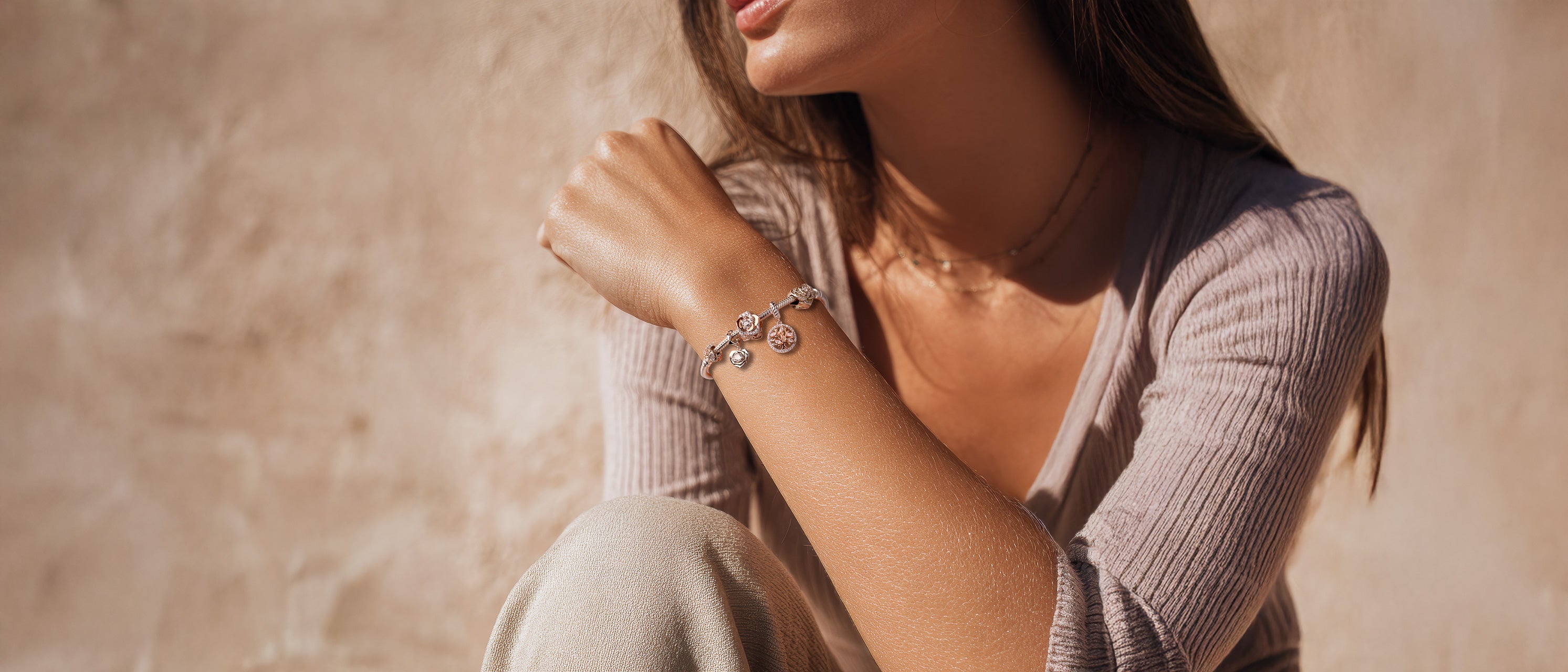 Frau trägt Armband mit Charms Set ROSÉ BLOOM von Charmerie aus 925 Sterling-Silberslider_item_8nTYQg