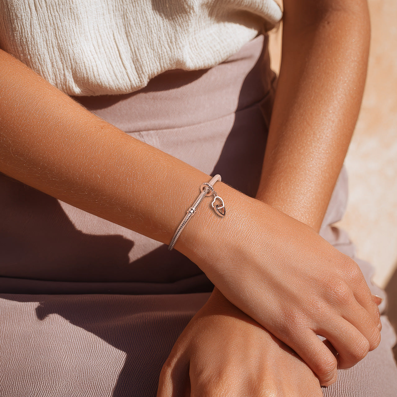 Frau trägt Armband und Herz-Charm von Charmerie aus 925 Sterling-Silber