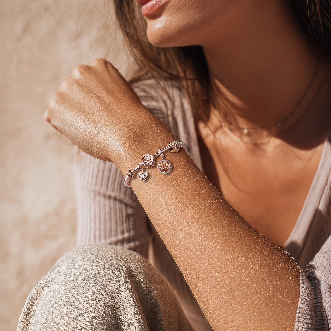 Frau trägt Armband mit Charms Set ROSÉ BLOOM von Charmerie aus 925 Sterling-Silber